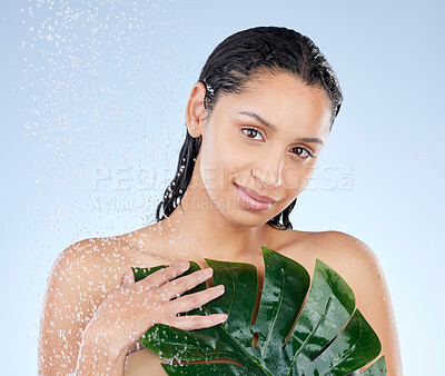 Buy stock photo Studio portrait of an attractive young woman taking a shower against a blue background