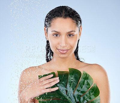 Buy stock photo Studio portrait of an attractive young woman taking a shower against a blue background