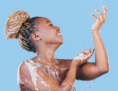 Buy stock photo Studio shot of an attractive young woman showering against a blue background