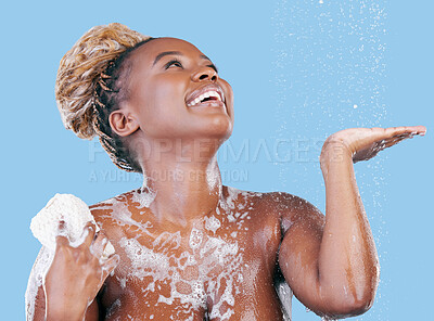 Buy stock photo Studio shot of an attractive young woman showering against a blue background