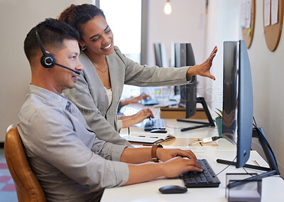 Buy stock photo Shot of two call centre agents working together on a computer in an office