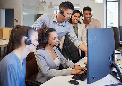 Buy stock photo Shot of a group of call centre agents working together on a computer in an office