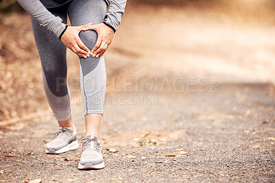 Buy stock photo Shot of an unrecognisable woman experiencing knee pain while working out in nature