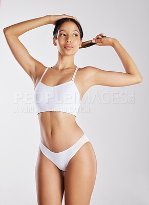 Buy stock photo Shot of a young woman posing in her underwear against a white background