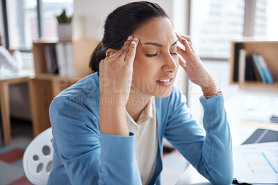 Buy stock photo Shot of a young businesswoman looking stressed while working at her desk in a modern office