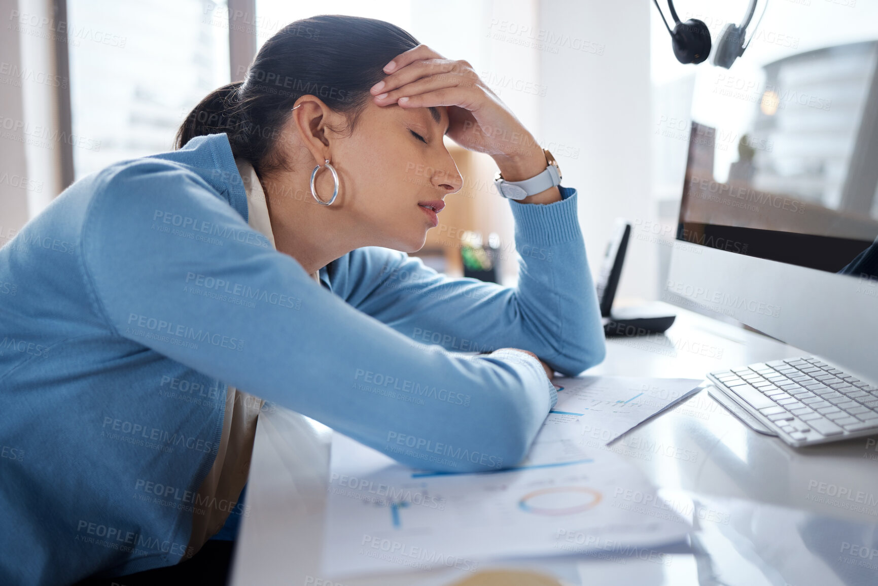 Buy stock photo Shot of a young businesswoman looking stressed while using a laptop at her desk in a modern office