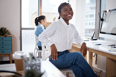 Buy stock photo Shot of a young businesswoman using a computer at her desk in a modern office