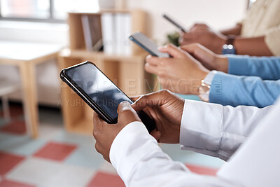 Buy stock photo Shot of a group of unrecognisable businesspeople using their smartphones in a modern office