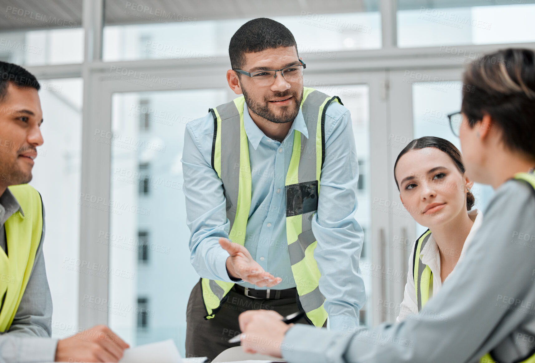 Buy stock photo Cropped shot of a group of young constructions having a meeting on their building site