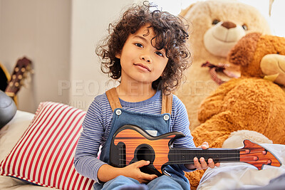 Buy stock photo Music, portrait and toy guitar with boy in bedroom of home for instrument fun or practice. Break, development and learning with confident child playing pretend musician on sofa to relax for weekend