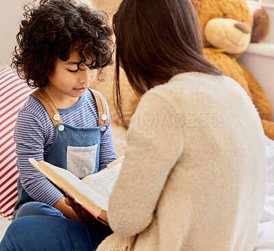 Buy stock photo Shot of a little boy and his mother reading together at home