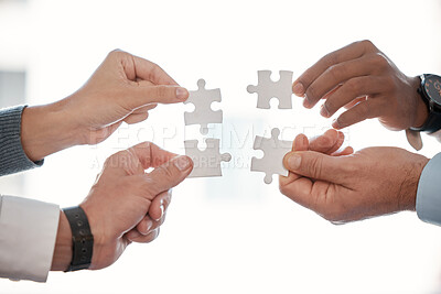 Buy stock photo Cropped shot of four unrecognizable businesspeople building a puzzle in the office