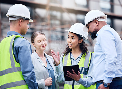 Buy stock photo Shot of a group of architects using a digital tablet at a building site