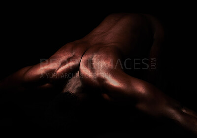 Buy stock photo Artistic shot of a muscular young man posing in studio against a dark background