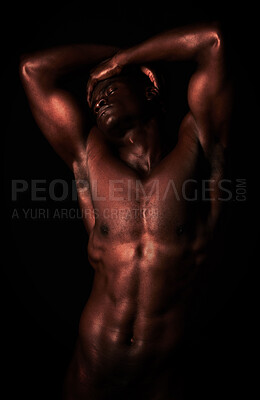 Buy stock photo Artistic shot of a muscular young man posing in studio against a dark background