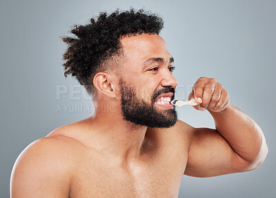 Buy stock photo Dental care, man or brushing teeth in studio for hygiene, whitening or clean with bamboo toothbrush. Male person, organic product or wooden tool on gray background for fresh breath, routine or health