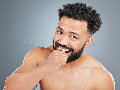 Buy stock photo Man, portrait and brushing teeth with toothbrush in studio for dental care, plaque removal and fresh breath for mouth. Person, gray background and oral hygiene for wellness routine and white smile.