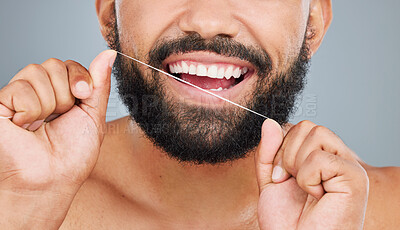 Buy stock photo Oral health, floss and mouth of man in studio for hygiene, plaque removal or clean with thread. Male person, organic product or dental wellness on gray background for fresh breath, routine or care