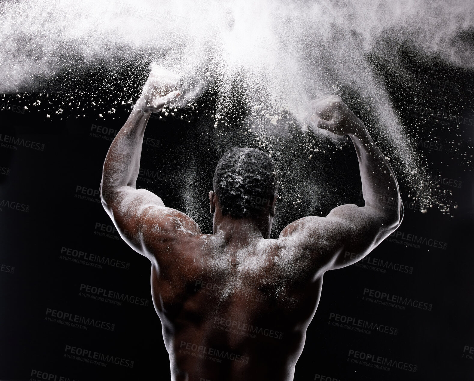 Buy stock photo Artistic shot of a muscular young man posing with white powder in studio against a dark background
