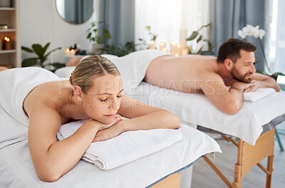 Buy stock photo Massage, calm and peaceful couple lying in spa for wellness treatment or at a luxury resort or vacation. Bed, zen and relaxing partners indoors or stress relief or physical therapy and body care