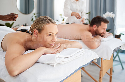 Buy stock photo Peace, couple and spa for hot stone massage, relax on holiday and wellness with weekend break, smile and stress relief. Honeymoon, man and woman with vacation, rocks and time together with luxury