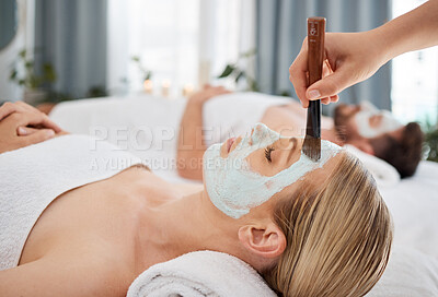 Buy stock photo Hand, brush and mask with a couple in a spa to relax on a massage table at a luxury resort together. Wellness, skincare and face treatment with a woman customer waiting for a facial from a masseuse