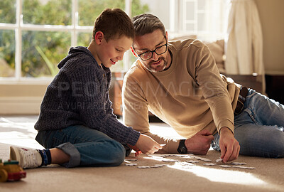 Buy stock photo Shot of a father and son bonding on the lounge floor at home
