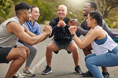Buy stock photo Shot of a group of sporty young people doing squats while exercising together outdoors