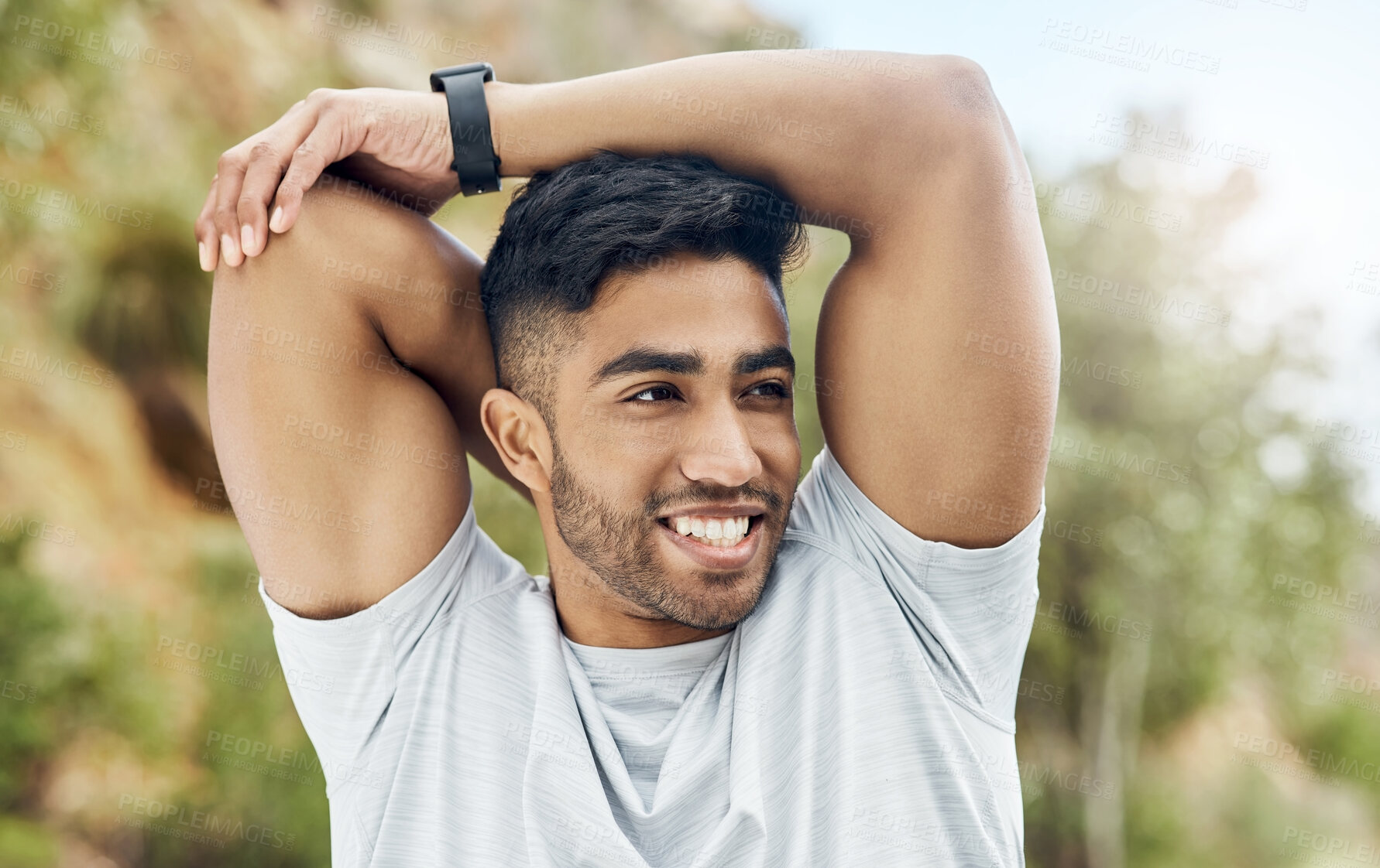 Buy stock photo Shot of an athletic young man stretching outside