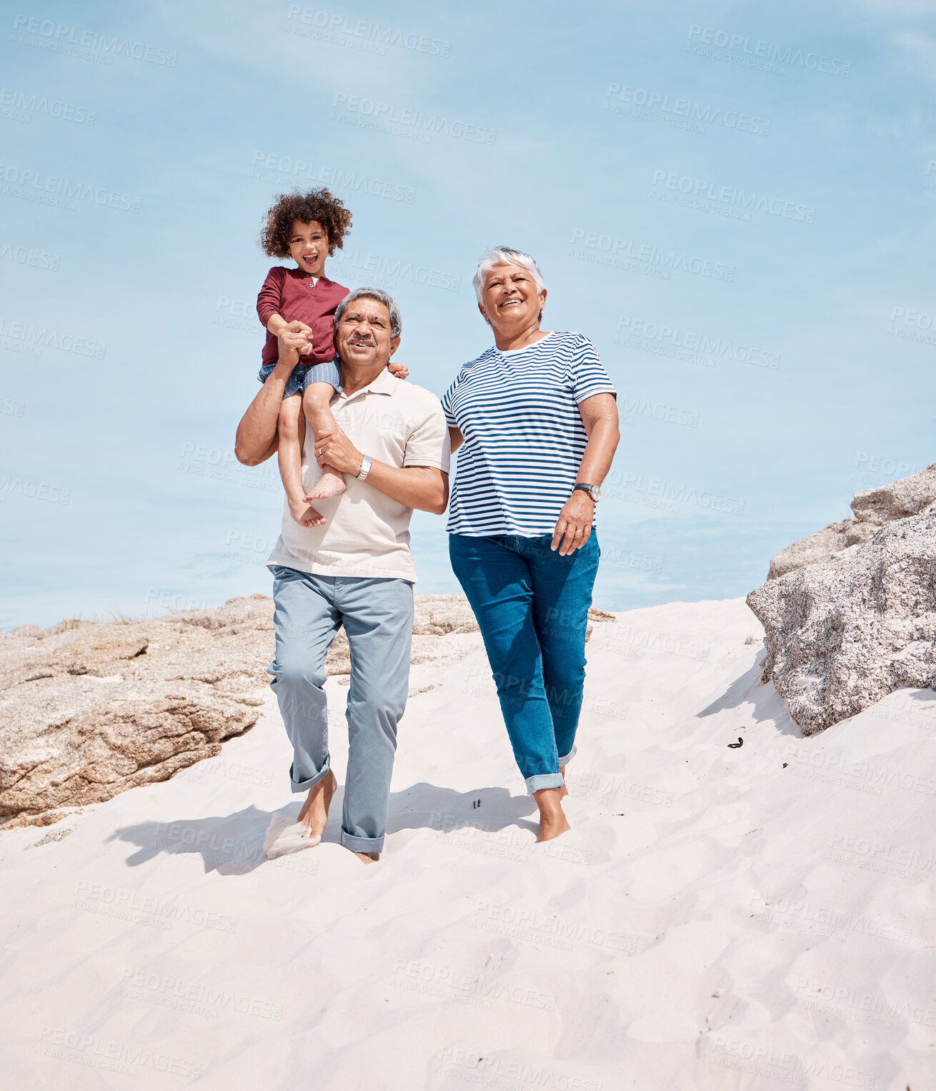Buy stock photo Shot of an adorable little boy at the beach with his grandparents