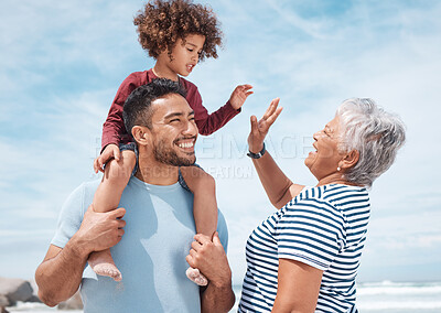Buy stock photo Shot of a little boy at the beach with his father and grandmother
