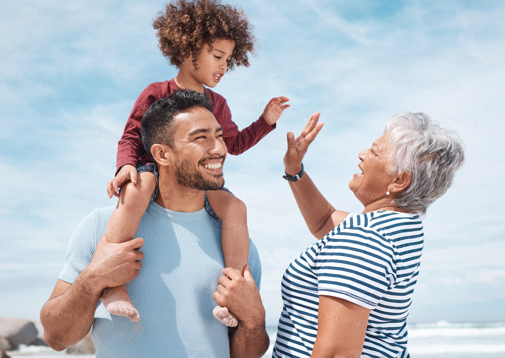 Buy stock photo Shot of a little boy at the beach with his father and grandmother