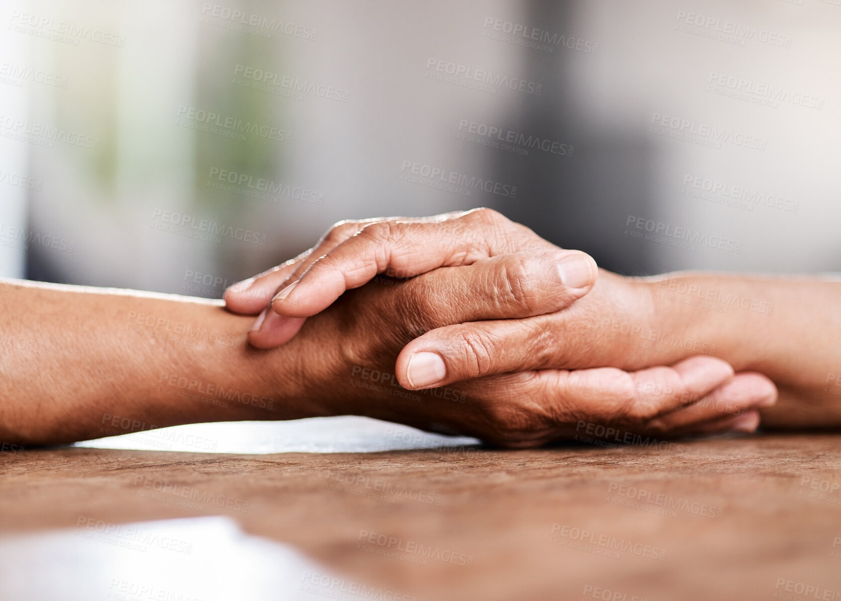 Buy stock photo Shot of an unrecognizable senior couple holding hands and comforting one another at home