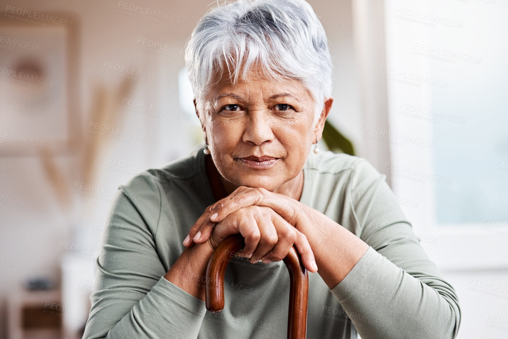 Buy stock photo Shot of a senior woman leaning in her walking stick at home