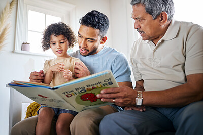 Buy stock photo Shot of a little girl reading a book with her father and grandfather at home