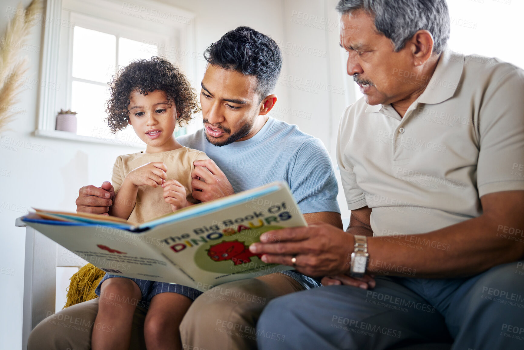 Buy stock photo Shot of a little girl reading a book with her father and grandfather at home