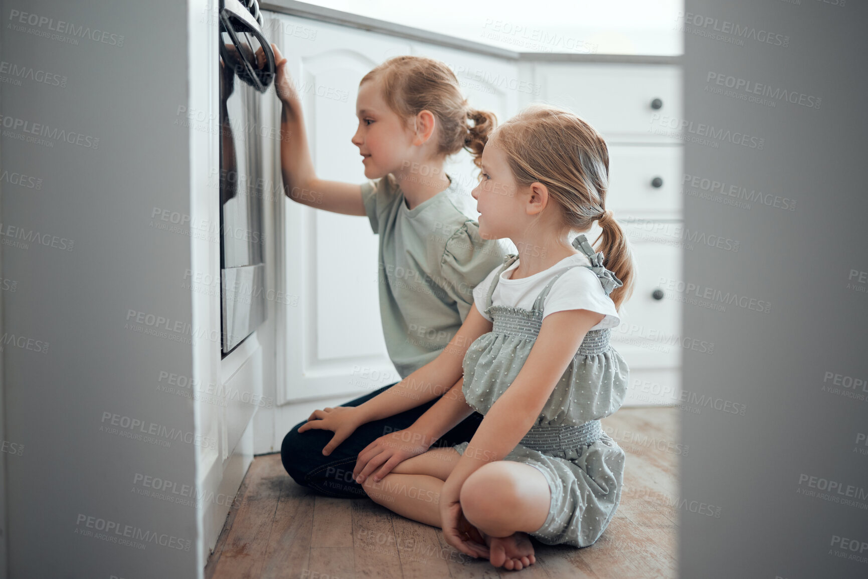 Buy stock photo Girl, children and waiting by oven in kitchen on floor with excitement for baking, cooking and growth or development. Female kids, siblings and together on ground in house for observe and patience.