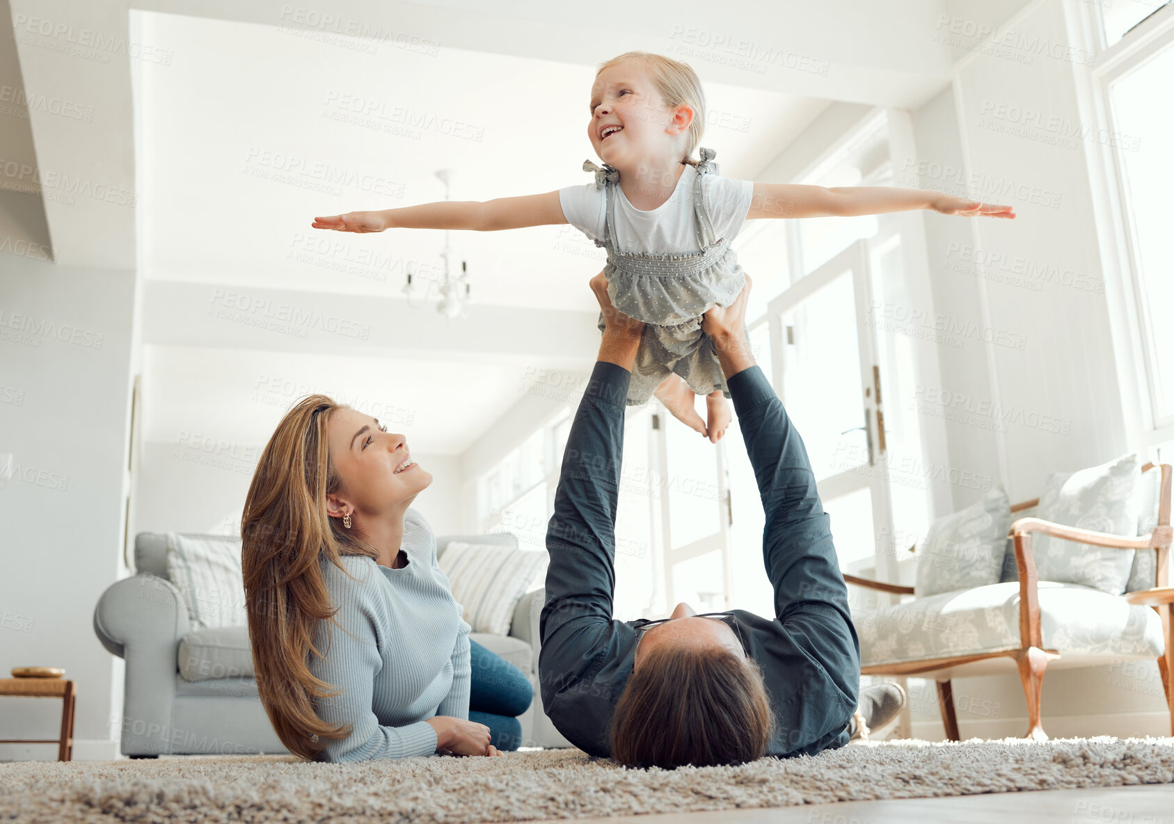 Buy stock photo Shot of a family bonding playfully on the lounge floor together