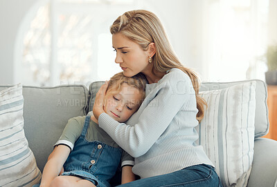 Buy stock photo Shot of a young mother comforting her daughter on the sofa at home