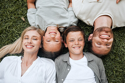 Buy stock photo Shot of a young couple lying outside with their two children