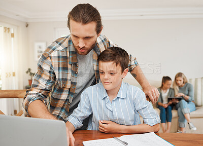 Buy stock photo Shot of a young father helping his son with homework at the kitchen table