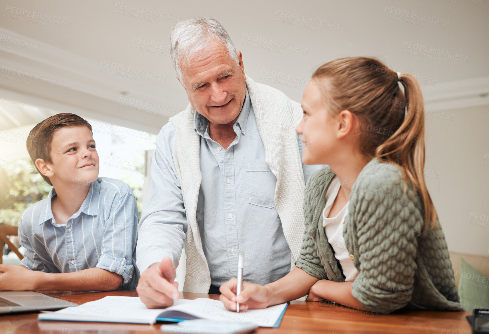 Buy stock photo Shot of a grandfather helping his grandkids with homework at home