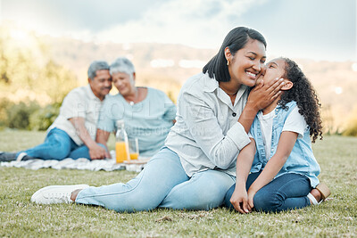 Buy stock photo Little girl kissing her mother on the cheek bonding with grandparents in the background. Mature couple having a picnic meal outside relaxing with their children. Family relaxing together in their yard