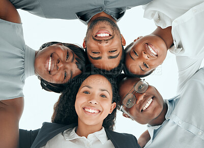 Buy stock photo Low angle portrait of a diverse group of young businesspeople standing in a huddle in the office