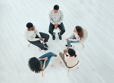 Buy stock photo High angle shot of an unrecognisable group of people sitting together and talking during therapy