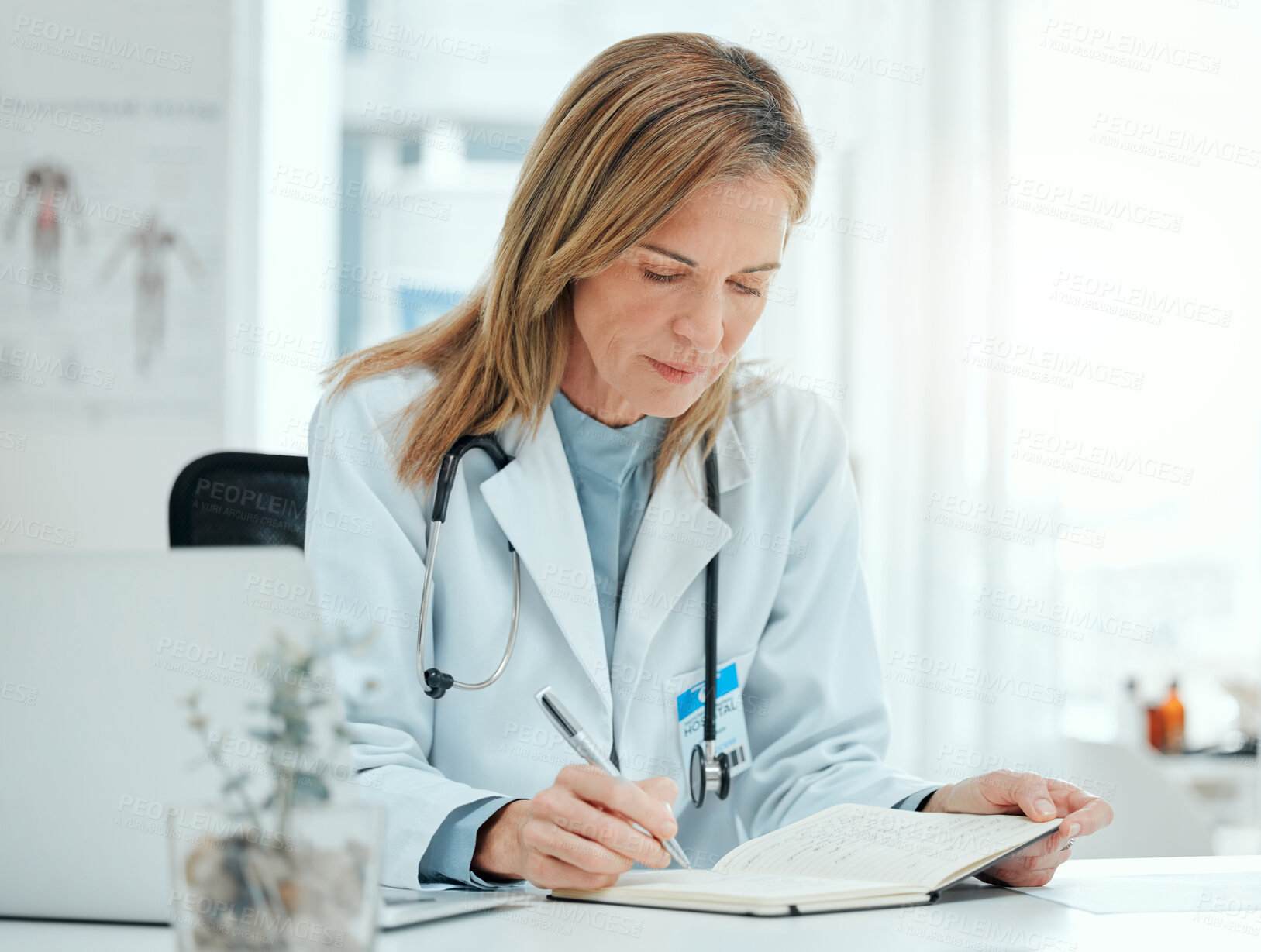 Buy stock photo Mature doctor, book and writing in office for schedule, notes and tracking patient treatment plan. Healthcare, cardiologist and journal in practice for planning, research and medical observation