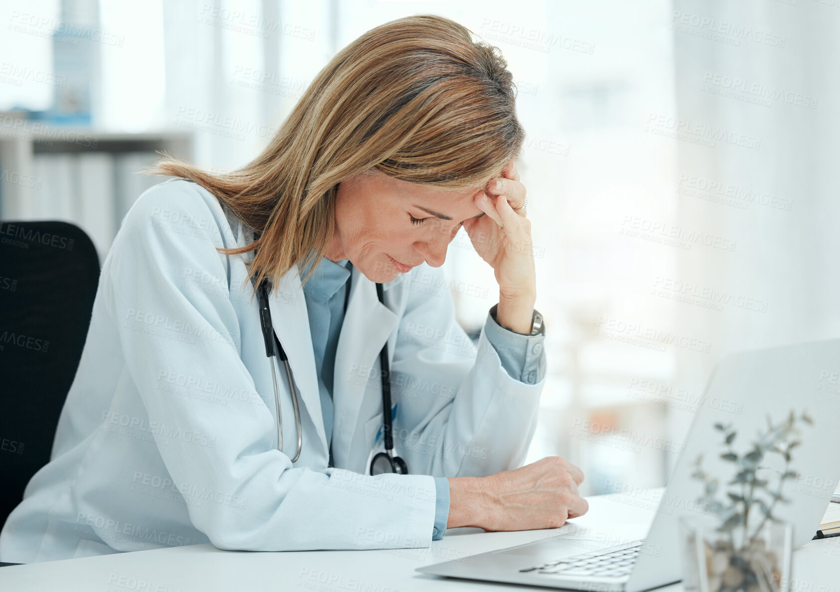 Buy stock photo Doctor, stress and headache at laptop for mistake, clinical error and depression in office. Healthcare, mature cardiologist and anxiety in practice for misdiagnosis, patient loss or tension in career