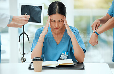 Buy stock photo Shot of a young female doctor looking stressed out in a demanding work environment
