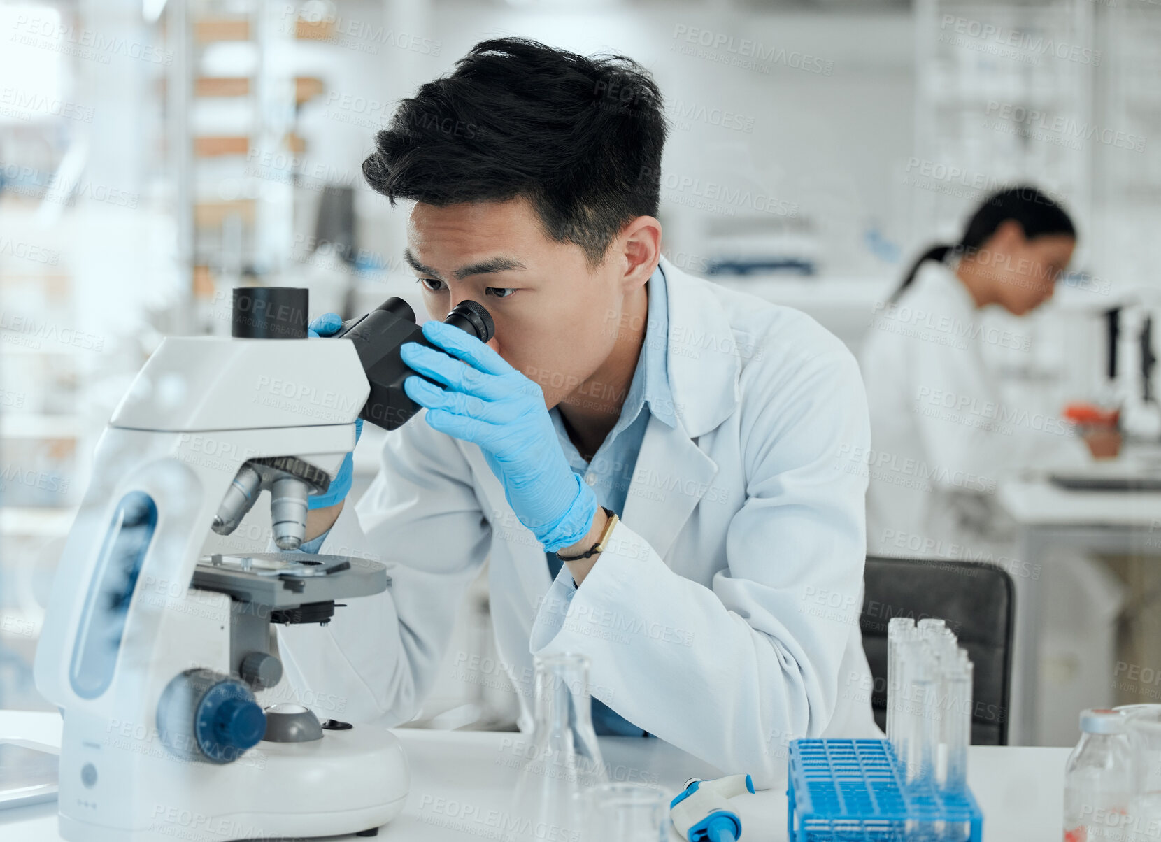 Buy stock photo Man, microscope and research in lab for science, observation and experiment results. Scientist, tech and study at table for medicine engineering, pharmaceutical development and healthcare innovation