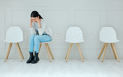 Buy stock photo Shot of a young woman looking stressed while waiting in line at an office